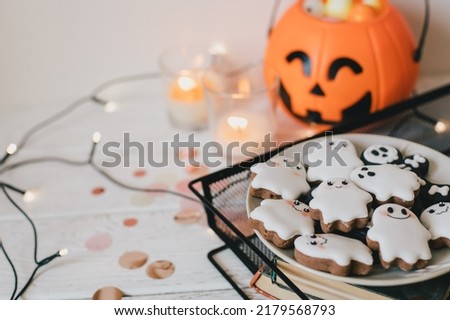 Funny scary Halloween ghost cookies on white wooden background. Trick or treat