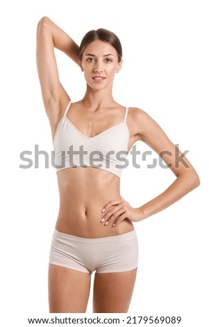 Young tanned woman in underwear on white background