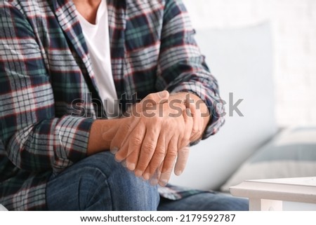 Mature man with Parkinson syndrome at home, closeup Royalty-Free Stock Photo #2179592787