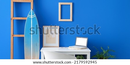 Interior of modern room with surfboard and workplace