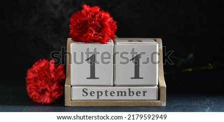 Calendar with date of National Day of Prayer and Remembrance for the Victims of the Terrorist Attacks and carnation flowers on dark background