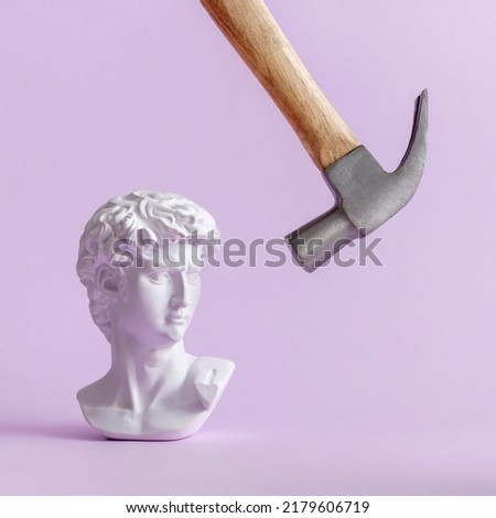 David historical plaster statue of Michelangelo in vaporwave style and a hammer makes a blow. Minimal creative concept on phyllote pastel background. Royalty-Free Stock Photo #2179606719