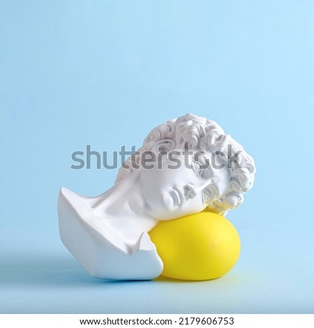 The head and face of David of an antique statue lies on a yellow balloon as a minimal trend concept of vaporwave surreal or sleep. Royalty-Free Stock Photo #2179606753