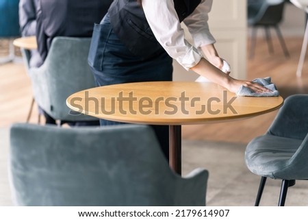 Hall staff cleaning a table. Restaurant clerk. Royalty-Free Stock Photo #2179614907
