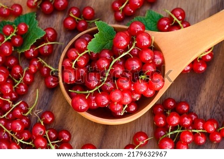 Red currant heap. Currant red with leaf on wooden background. Organic currants with soft focus. Currant top view.  Royalty-Free Stock Photo #2179632967