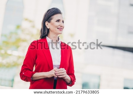 Photo of dreamy charming mature lady boss wear red jacket walking work outside city business complex