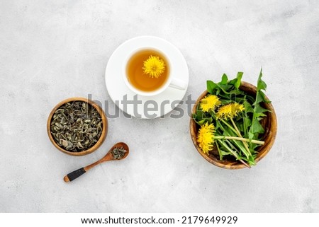 Yellow meadow dandelions with tea and dry leaves in bowl, top view Royalty-Free Stock Photo #2179649929