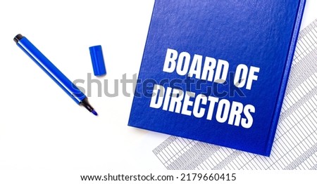 On a white background reports, a blue pen and a blue notebook with the text BOARD OF DIRECTORS. Business concept. Banner