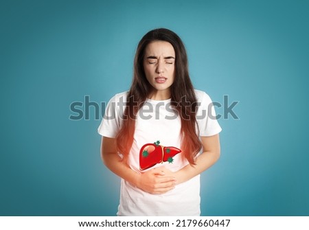 Sick woman suffering from pain and illustration of unhealthy liver on light blue background. Viral hepatitis Royalty-Free Stock Photo #2179660447