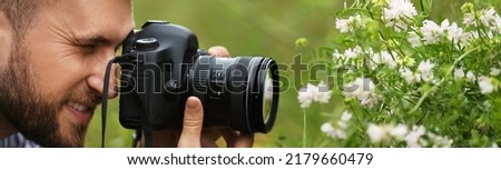 Photographer taking picture of beautiful plants with professional camera outdoors. Banner design
