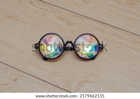 designer glasses with kaleidoscope lenses on wooden background