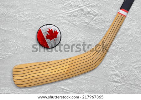 Hockey stick and puck on Canadian ice.