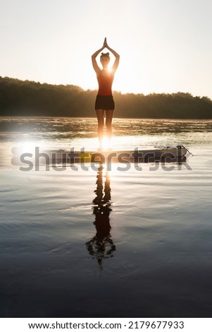 A woman cooling herself down and practicing yoga during sunrise.