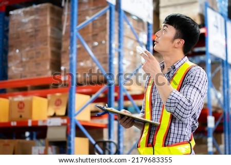 A man in charge of a large warehouse is checking the number of items in the warehouse that he is responsible for.