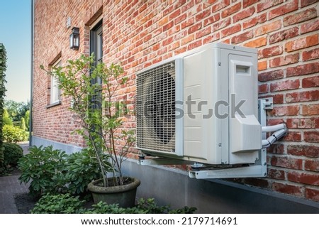 Air to air heat pump for cooling or heating the home. Outdoor unit powered by renewable energy. Royalty-Free Stock Photo #2179714691