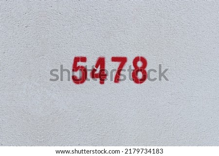 Red Number 5478 on the white wall. Spray paint.
