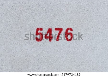 Red Number 5476 on the white wall. Spray paint.
