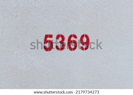Red Number 5369 on the white wall. Spray paint.
