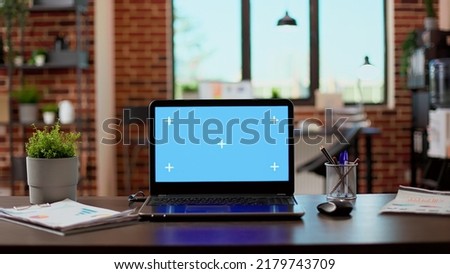 No people in empty office with greenscreen display on laptop, isolated copyspace template on modern computer. Blank chroma key background with mockup screen on pc network at desk.