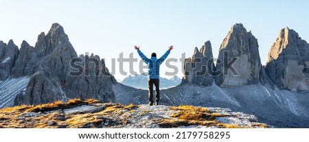 Tourist in blue jacket at Three Peaks of Lavaredo track on autumn season. National Park Tre Cime di Lavaredo, Dolomite Alps mountains, Trentino Alto Adige region, Sudtirol, Dolomites, Italy Royalty-Free Stock Photo #2179758295