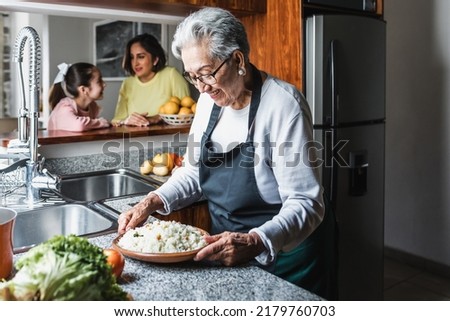 Hispanic women grandmother and granddaughter cooking at home kitchen in Mexico Latin America Royalty-Free Stock Photo #2179760703
