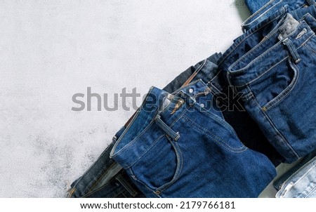 Clothes and jeans,Stack of colorful perfectly folded clothing items. Pile of different pastel color shirts, sweaters isolated and other garments on white background. Close up, copy space.