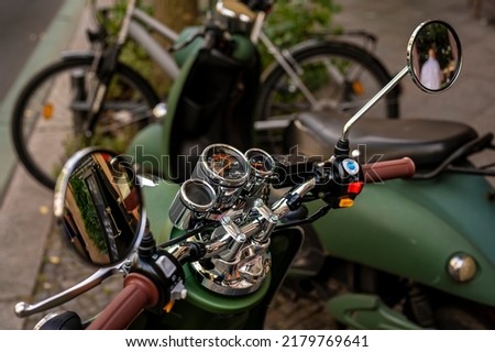 View to the chromed instruments on the handlebars of a vintage style scooter.