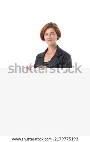 Redhead pretty young woman holding large blank white sign in front of her isolated on white background