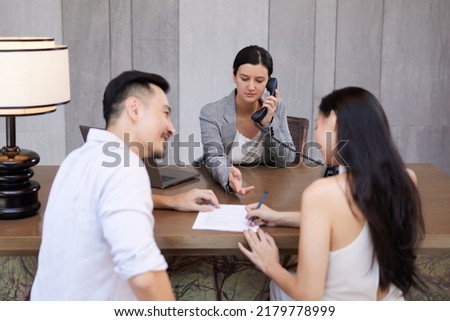 Young happy asian couple signing contract, making legal deal, taking loan or mortgage, purchasing real estate, new apartment, meeting with banker or consulting agent