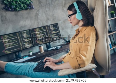 Profile side view portrait of attractive focused girl editing network intranet developing web startup at workplace workstation indoors