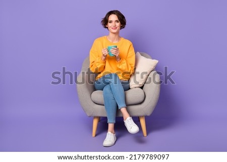 Full size photo of gorgeous positive person sit chair hold coffee cup isolated on violet color background