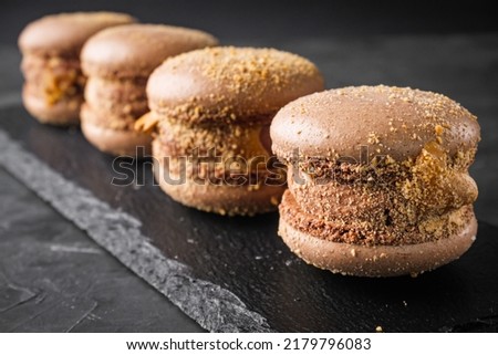 colored macaroons on a dark stone background.