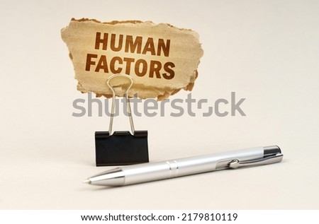 Industry and business concept. Next to the handle is an office clip with a sign. On the plate is the inscription - Human Factors