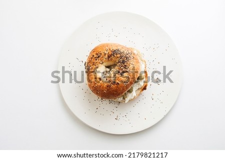 Everything Bagel topped with cream cheese and green olives Royalty-Free Stock Photo #2179821217
