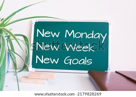 Text New Monday New Week New Goals written on the green chalkboard