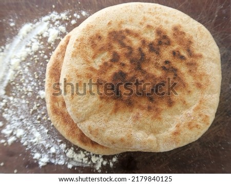 Homemade  arabic wheat bread in wooden background and spreaded flour         