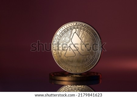 Avalanche AVAX Cryptocurrency Physical Coin Placed on reflective surface and lit with red and purple lights. Royalty-Free Stock Photo #2179841623