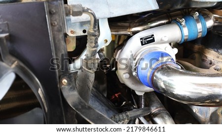 Turbocharged car engine. booster or round silver metal air compressor with air intake system mounted on diesel engine with copy space. Selective focus Royalty-Free Stock Photo #2179846611