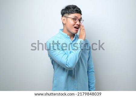 Young handsome man casual shirt and glasses over white background hand on mouth telling secret rumor, whispering malicious talk conversation Royalty-Free Stock Photo #2179848039