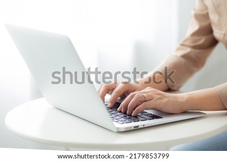 Closeup hands of businesswoman working on laptop computer on desk at home office, freelance looking and typing on notebook on table, lifestyles of woman studying online, business concept. Royalty-Free Stock Photo #2179853799