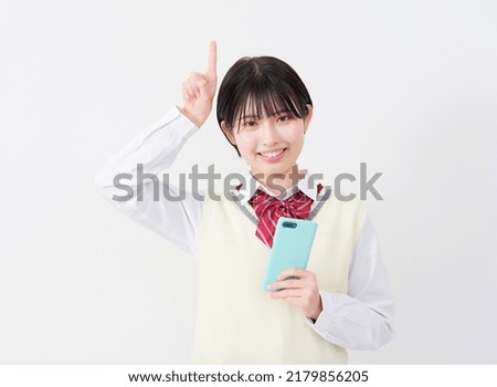 Asian high school student pointing to top in white background