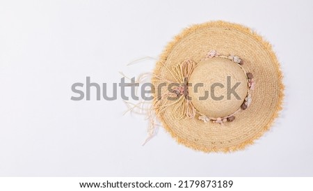Closeup studio top view isolated shot of beautiful fashionable Asian modern classic style lady woman wicker woven weaving rattan handmade handicraft hat with dry flowers hatband on white background. Royalty-Free Stock Photo #2179873189