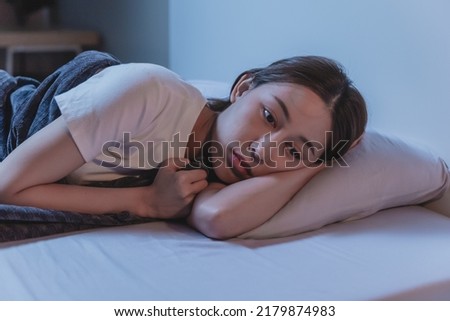 Asian women opened eyes lying on the bed have an insomnia problems. Royalty-Free Stock Photo #2179874983