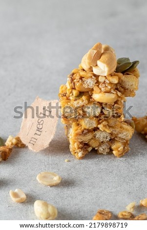 Granola bar with nuts and pumpkin seeds close-up on a gray background