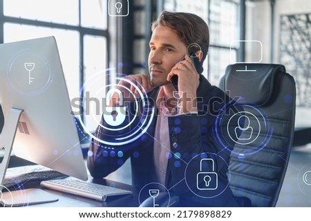 Businessman in suit has conference call of cyber security in compliance division to protect clients confidential information. IT hologram lock icons over office background with panoramic windows.