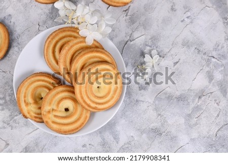 Round ring shaped spritz biscuits, a type of German butter cookies made by extruding dough with a press fitted with patterned holes Royalty-Free Stock Photo #2179908341