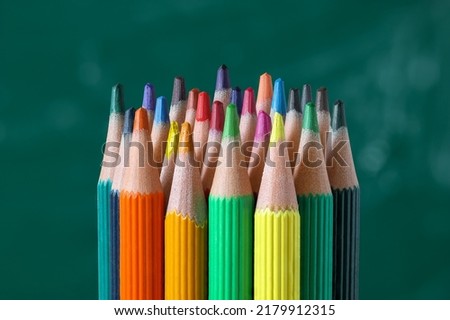 A set of colored pencils on the background of the school board.
