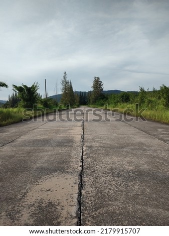 concrete road in the countryside. lonely country road.  (The pictures has noise and soft focus)