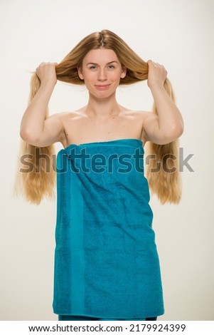 beauty portrait of a girl with long hair. close-up of a blonde woman with natural long hair in a towel on a white background .hair care health diet concept.