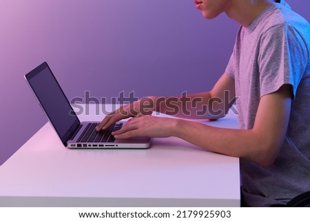 curly guy in front of laptop entertainment violet background